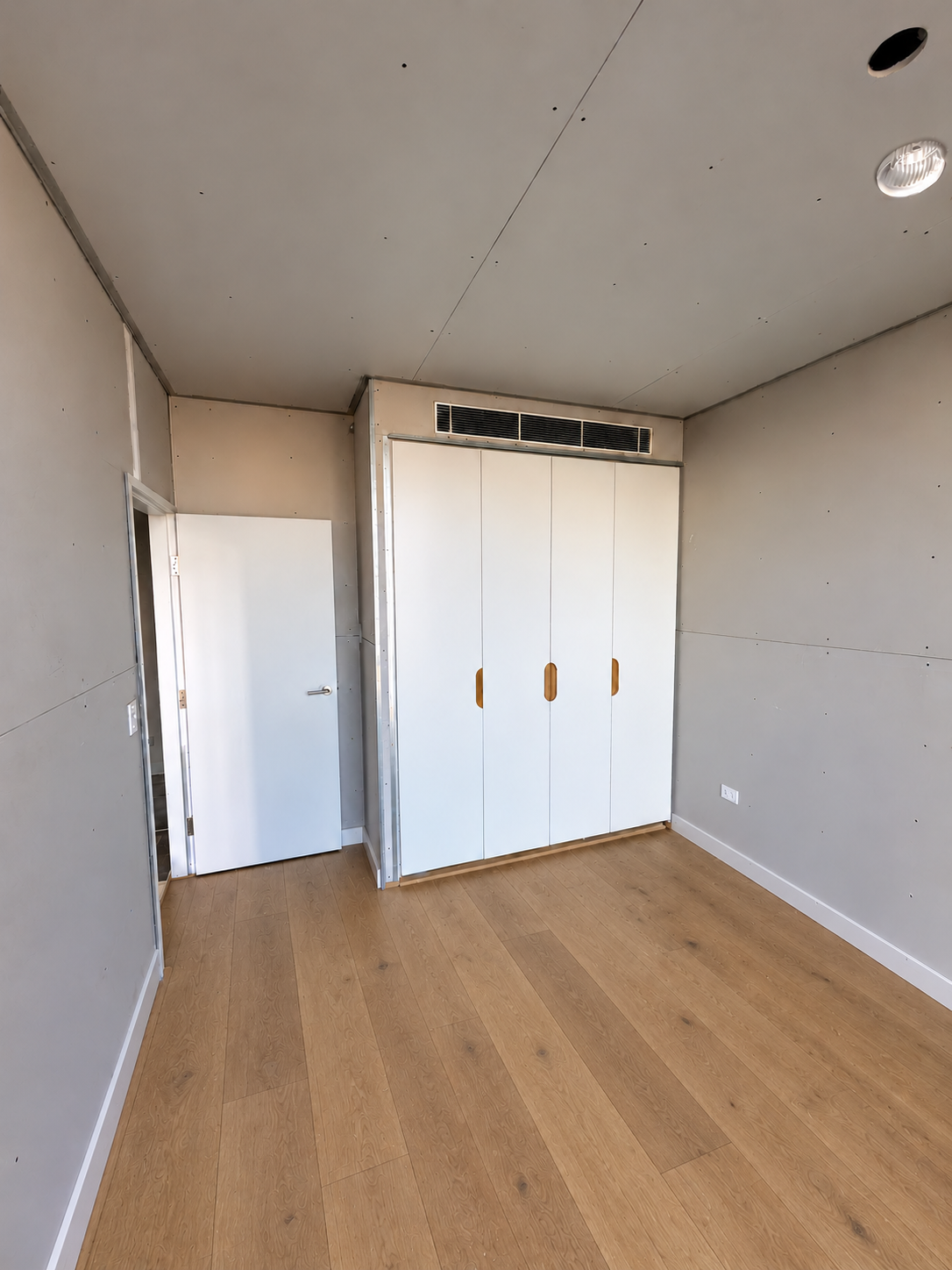 White wardrobe installation with recessed timber handles